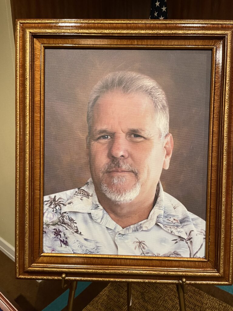 Portrait of man printed and framed on an easel. 