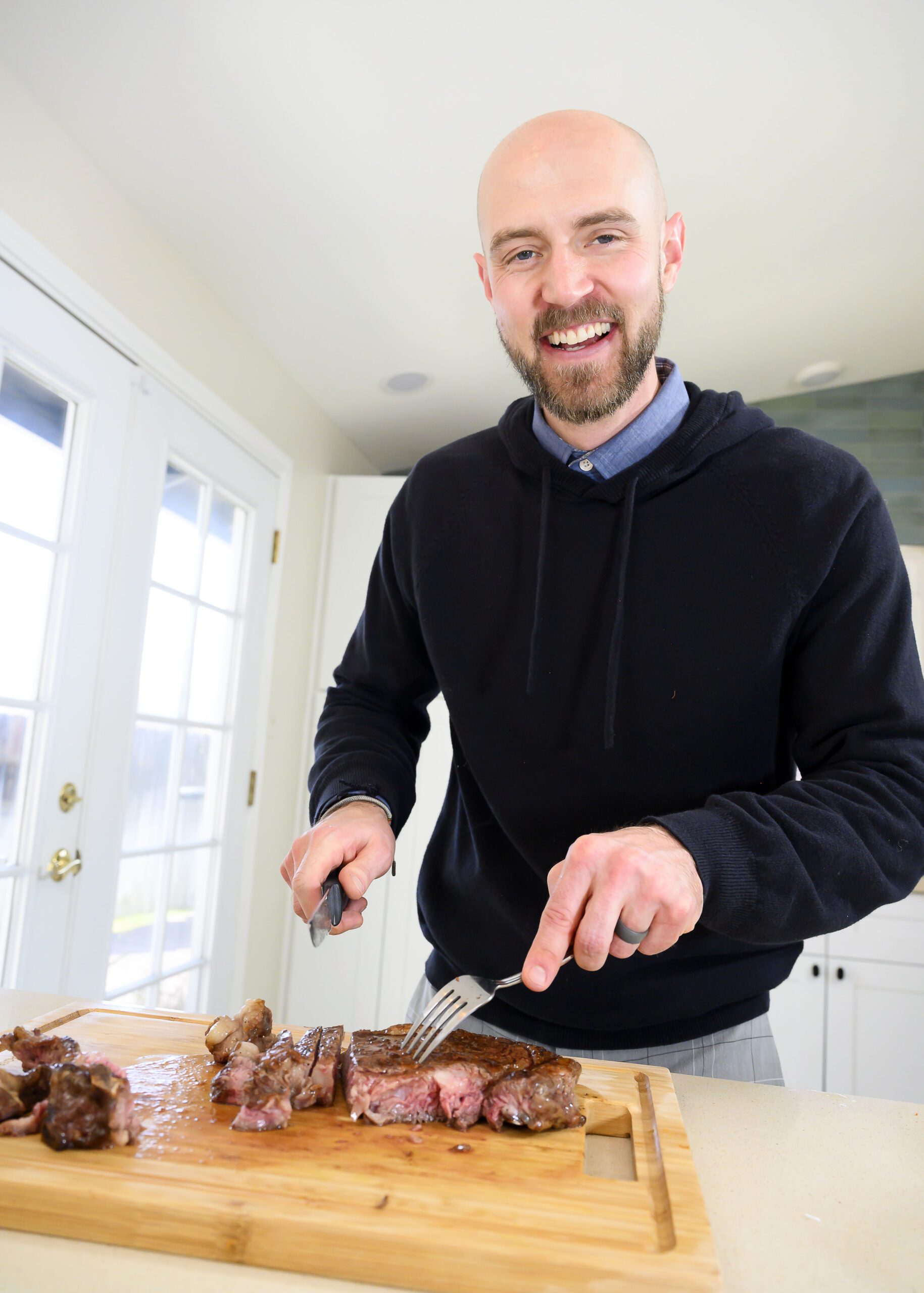 Man cuts steak on kitchen counter